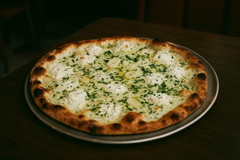 Scarr's Pizza white pie with ricotta, garlic, and parsley on a metal tray.